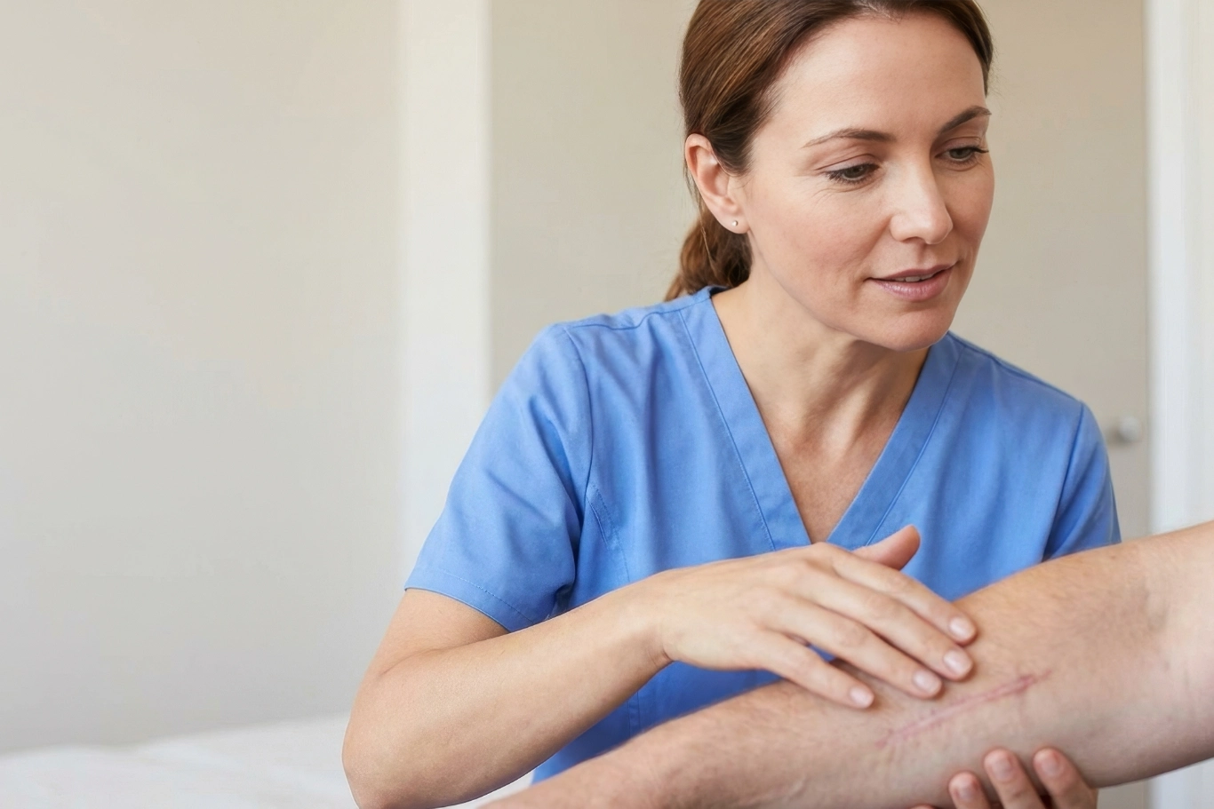 Nurse examining a patients healing scar on the arm during a consultation